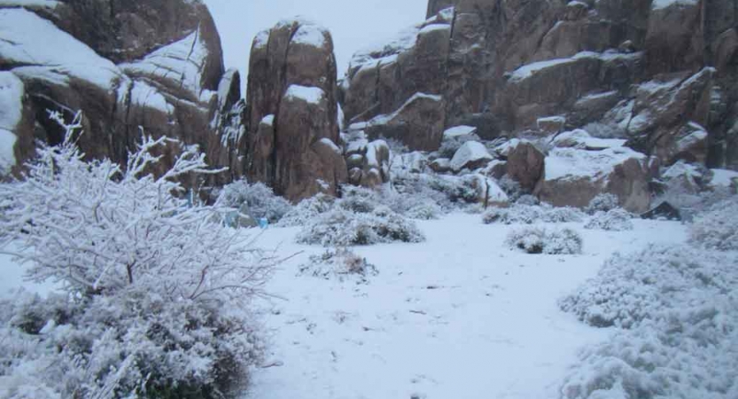 Snow covers boulders in a desert landscape